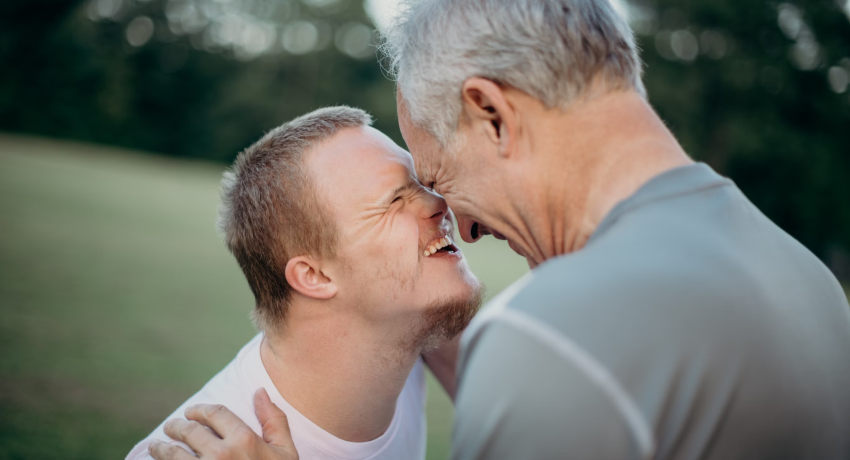 A man with down syndrome and another man laughing and having fun